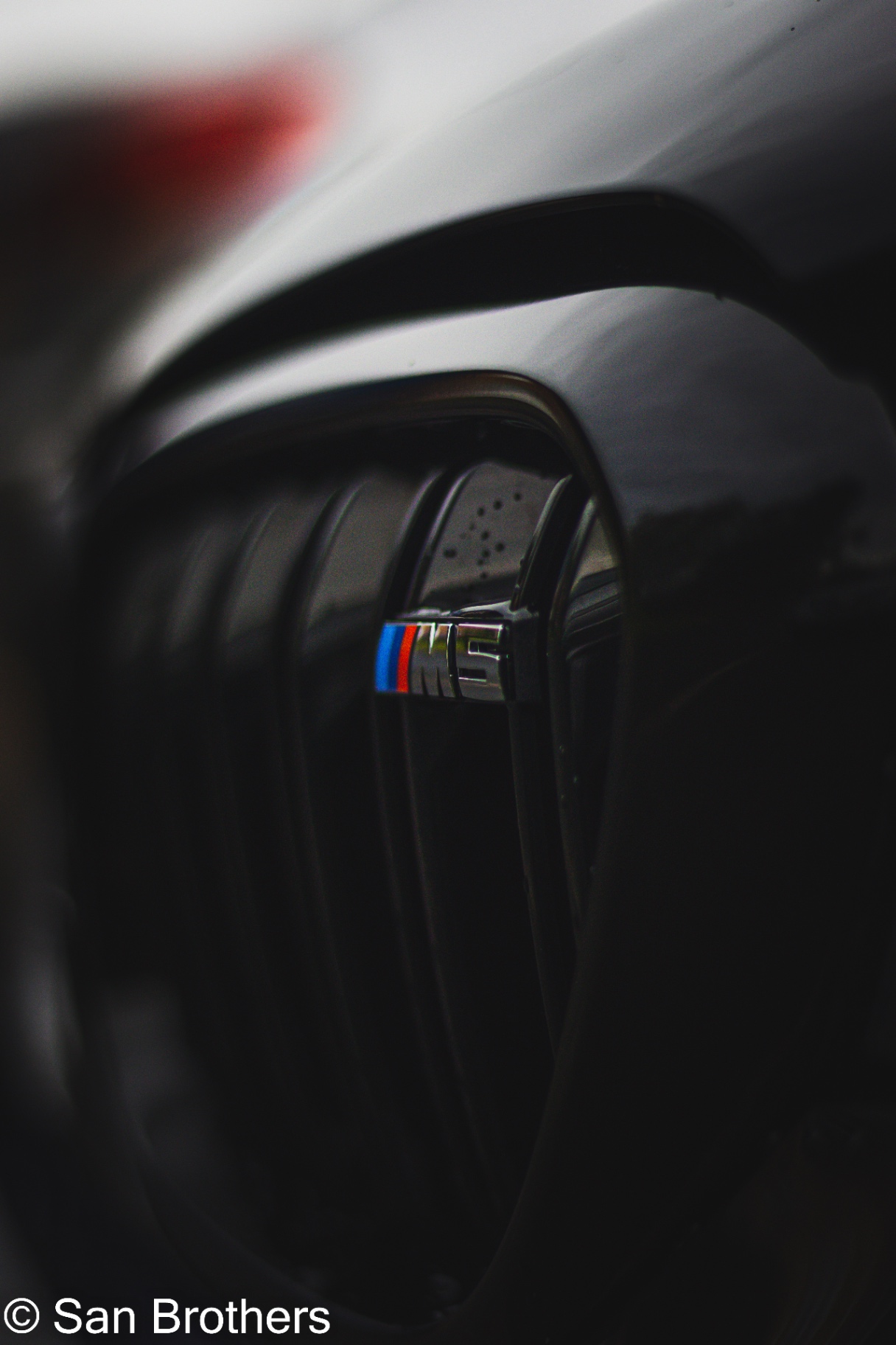 Close-up of the BMW M5 badge on a glossy kidney grille