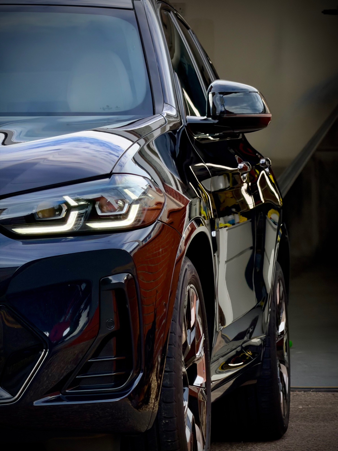 Two black BMW SUVs with mirror-gloss paintwork after full detail